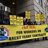 Các thành viên Liên đoàn công nhân đường sắt, hàng hải và vận tải quốc gia (RMT) Anh tuần hành bên ngoài Bộ Giao thông ở London. (Ảnh: AFP/TTXVN)