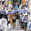 Người dân che ô tránh nắng nóng khi di chuyển trên đường phố tại Tokyo, Nhật Bản, ngày 28/6/2022. (Ảnh: Kyodo/TTXVN)