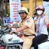 Thiếu tá Nguyễn Tường Duy và thí sinh Nguyễn Thị Thu Vân kịp thời trở lại điểm thi. (Ảnh: TTXVN phát)