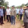 Chủ tịch UBND tỉnh Cà Mau Huỳnh Quốc Việt (áo xanh, trái) lắng nghe ý kiến của ngành chức năng về việc đầu tư, hoàn thiện một dự án tái định cư cho người dân ven biển Tây. (Ảnh: Huỳnh Anh/TTXVN)