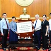 Chủ tịch Ủy ban Trung ương Mặt trận Tổ quốc Việt Nam Đỗ Văn Chiến tiếp nhận tài trợ của Tập đoàn Masterise Group. (Ảnh: Minh Đức/TTXVN)