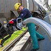 Công nhân vận hành ống dẫn nhiên liệu lỏng tại cơ sở lọc dầu ở thị trấn Szazhalombatta, Hungary. (Ảnh: AFP/TTXVN)