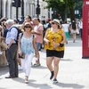 Người dân di chuyển trên đường phố dưới trời nắng nóng tại London, Anh, ngày 11/7/2022. (Ảnh: THX/TTXVN)