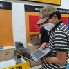 Khách hàng lựa chọn mua laptop tại một cửa hàng điện máy trên địa bàn thành phố Bà Rịa. (Ảnh: Hoàng Nhị/TTXVN)