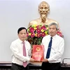 Phó Chủ tịch Thường trực UBND tỉnh Bình Định Nguyễn Tuấn Thanh (trái) trao quyết định cho ông Đặng Vĩnh Sơn. (Ảnh: Nguyên Linh/TTXVN)