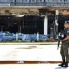 Một binh sỹ Thái Lan gác tại cửa hàng tiện lợi ở huyện Cho-airong, tỉnh Narathiwat sau loạt vụ tấn công ngày 17/8/2022. (Ảnh: AFP/TTXVN)