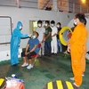 Lực lượng y tế tiến hành test COVID-19 cho 8 người nước ngoài bị nạn trên biển. (Ảnh: TTXVN phát)