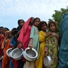 Người dân xếp hàng chờ nhận lương thực cứu trợ tại trại tị nạn ở Sehwan, tỉnh Sindh, Pakistan, sau khi phải rời bỏ nhà cửa tránh lũ lụt ngày 13/9/2022. (Ảnh: AFP/TTXVN)