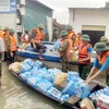 Lực lượng chức năng vận chuyển lương thực, nước uống hỗ trợ người dân vùng bị ngập tại huyện Quỳnh Lưu (Nghệ An). (Ảnh: Tá Chuyên/TTXVN)