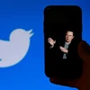 Hình ảnh tỷ phú Elon Musk trên màn hình điện thoại và biểu tượng Twitter trên màn hình máy tính tại Washington, DC, Mỹ. (Ảnh: AFP/TTXVN)