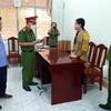 Lực lượng chức năng đọc lệnh bắt tạm giam đối với Ninh Thị Vân Anh. (Ảnh: TTXVN phát)