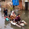 Người dân tại khu vực bị ảnh hưởng bởi mưa lũ ở Hyderabad, Pakistan ngày 19/8/2022. (Ảnh: AFP/TTXVN)