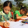 Học sinh trường Tiểu học Tùng Bá (huyện Vị Xuyên) tham gia vẽ tranh về chủ đề bảo tồn Voọc mũi hếch tại lễ hội. (Ảnh: Minh Tâm/TTXVN)
