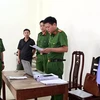 Cơ quan Cảnh sát điều tra Công an tỉnh Nghệ An đọc lệnh bắt tạm giam Lê Văn Bình. (Ảnh: TTXVN phát)