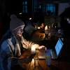 Người dân tới quán càphê ở Lviv, khi nhiều hộ gia đình đang phải chịu cảnh cắt điện luân phiên ngày 24/11/2022. (Ảnh: AFP/TTXVN)