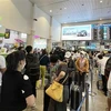 Hành khách xếp hàng làm thủ tục tại Sân bay Tân Sơn Nhất. (Ảnh: Tiến Lực/TTXVN)