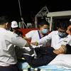 Các lực lượng y tế đang tiến hành kiểm tra sức khỏe của bệnh nhân khi được đưa vào thành phố Nha Trang để điều trị bệnh. (Ảnh: Phan Sáu/TTXVN)