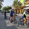 Du khách nước ngoài đi xe đạp trải nghiệm tại thành phố Bến Tre. (Ảnh: Huỳnh Phúc Hậu/TTXVN)