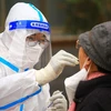Nhân viên y tế lấy mẫu xét nghiệm COVID-19 cho người dân tại tỉnh Cam Túc, Trung Quốc. (Ảnh: AFP/TTXVN)