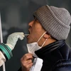 Nhân viên y tế lấy mẫu xét nghiệm COVID-19 cho người dân tại Bắc Kinh, Trung Quốc ngày 26/12/2022. (Ảnh: AFP/TTXVN)