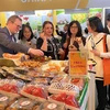 Các khách hàng quốc tế thưởng thức hoa quả Việt Nam tại Fruit Logistica 2023. (Ảnh: Phương Hoa/TTXVN)