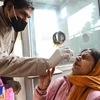 Nhân viên y tế lấy mẫu xét nghiệm COVID-19 cho người dân tại Amritsar, Ấn Độ. (Ảnh: AFP/TTXVN)