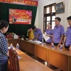 Nữ thủ kho (áo sọc) kiêm văn thư Chi cục Thi hành án dân sự thành phố Đông Hà bị khởi tố vào tháng 3/2023 vì sử dụng tài liệu giả để hợp thức hóa chứng từ để chiếm đoạt số tiền hơn 2,5 tỷ đồng. (Ảnh: Báo Lao động)