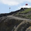 Quốc kỳ Azerbaijan (trái) và quốc kỳ Armenia tại trạm kiểm soát biên giới giữa hai nước ở làng Sotk (Armenia). (Ảnh: AFP/TTXVN)