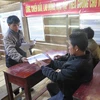 Cán bộ xã Măng Cành, huyện Kon Plông phát tài liệu tuyên truyền về động đất cho người dân. (Ảnh: Dư Toán/TTXVN)