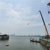 Du thuyền (đã bị chìm một phần) của Công ty cổ phần Sông Potomac đang được lực lượng chức năng kéo vào gần bờ rồi tiến hành tháo dỡ, di chuyển. (Ảnh Minh Nghĩa/TTXVN)