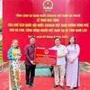 Đại diện Tổng Lãnh sự quán Việt Nam tại Pakse trao quà của Chủ tịch Quốc hội cho đại diện cộng đồng người Việt tại tỉnh Sekong. (Ảnh: TTXVN phát)