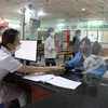 Bác sỹ Bệnh viện Sản-Nhi Bắc Ninh phát thẻ khách hàng cho bệnh nhân đến khám. (Ảnh: Thanh Thương/TTXVN)