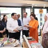 Thủ tướng Phạm Minh Chính mua sách tặng Thủ tướng Malaysia Anwar Ibrahim và Phu nhân. (Ảnh: Dương Giang/TTXVN)