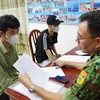 Lực lượng chức năng rà soát thông tin của các công dân vừa tiếp nhận từ lực lượng chức năng Campuchia. (Ảnh: Thanh Tân/TTXVN)