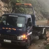 Đơn vị chức năng triển khai công tác cứu hộ cứu nạn xe ôtô bán tải bị đất đá rơi vào. (Ảnh: TTXVN phát)