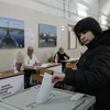 Cử tri bỏ phiếu bầu Tổng thống Nga tại điểm bầu cử ở St. Petersburg. (Ảnh: THX/TTXVN)