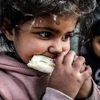 Một em bé Palestine ăn bánh mỳ trong một trại tị nạn thành phố Rafah, phía nam Dải Gaza. (Ảnh: DPA)