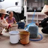 Người dân đến lấy nước tại điểm cấp nước ấp Pháo Đài, xã Phú Tân. (Ảnh: Minh Trí/TTXVN)