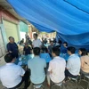 Lãnh đạo UBND huyện Ba Vì thăm hỏi, chia sẻ với gia đình nạn nhân. (Ảnh: Mạnh Khánh/Vietnam+)