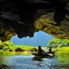 Các hang động được bao quanh bởi sông Ngô Đồng và những thảm lúa trải dài ven chân núi, đưa con người chìm đắm vào thiên nhiên. (Ảnh: Minh Đức/TTXVN)