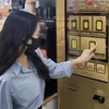 Một khách hàng mua vàng miếng bằng máy bán hàng tự động tại một cửa hàng tiện lợi ở Seoul. (Nguồn: UPI News)