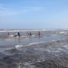 Du khách vui đùa và tắm biển ở bãi tắm thuộc Khu du lịch biển Ba Động. (Ảnh: Nguyễn Luân/Báo ảnh Việt Nam)