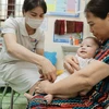 Nhân viên y tế Trung tâm Kiểm soát bệnh tật tỉnh (CDC) Hà Giang tiêm chủng cho trẻ. (Ảnh: Minh Quyết/TTXVN)