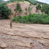 Toàn bộ diện tích 1ha ao nuôi cá của gia đình ông Bùi Văn Doanh ở thôn Đoàn Kết, xã Đại Sơn, bị đất đá vùi lấp. (Ảnh: Tuấn Anh/TTXVN)