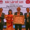 Tổ chức kỷ lục Việt Nam trao chứng nhận xác lập kỷ lục cho ông Nguyễn Phi Dũng, nhà sưu tầm báo giấy phát hành tại Việt Nam từ cuối thế kỷ 19 đến nay với số lượng nhiều nhất. (Ảnh: Công Luật/TTXVN)