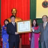 Chủ tịch Quốc hội Nguyễn Sinh Hùng trao tặng Huân chương Độc lập hạng Nhì cho ngành Kho bạc Nhà nước. (Ảnh: Nhan Sáng/TTXVN)