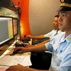 Cán bộ hải quan thực hiện kiểm tra hàng hóa qua màn hình điện tử. (Ảnh: Hải Âu/TTXVN)