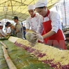 Các nhân viên Khách sạn Sài Gòn-Đông Hà chuẩn bị gạo, đỗ để gói bánh tét dâng cúng tại thành cổ Quảng Trị năm 2014. (Ảnh: Hồ Cầu/TTXVN)