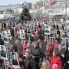 Người dân Nga mang ảnh người thân hy sinh trong Chiến tranh Thế giới thứ II tại lễ kỷ niệm 70 năm Ngày Chiến thắng ở thành phố Vladivostok ngày 9/5. (Nguồn: THX/TTXVN) 