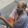 Bức ảnh anh Abdul ôm con gái Reem đi bán bút được đăng trên mạng. (Nguồn: edition.cnn.com) 
